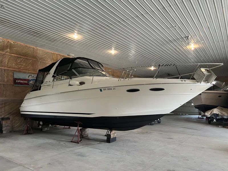 Slide: The Image of 1999 Sea Ray 310 Sundancer boat stored indoors on stands. - 4