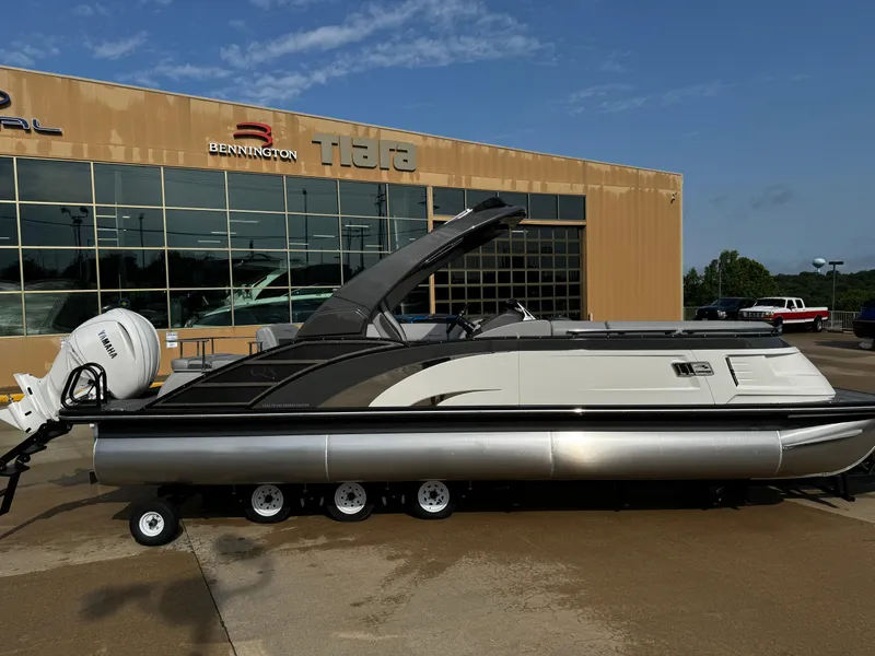 Slide: The Image of 2024 Bennington 25 QXSBA pontoon boat displayed outside dealership. - 10