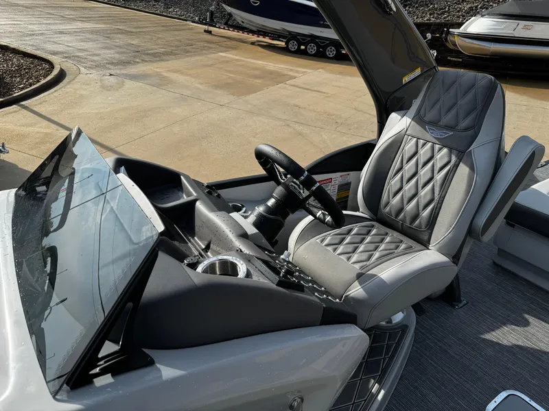 Slide: The Image of 2024 Bennington 25 QXSBA boat interior with luxurious seating and modern dashboard. - 17