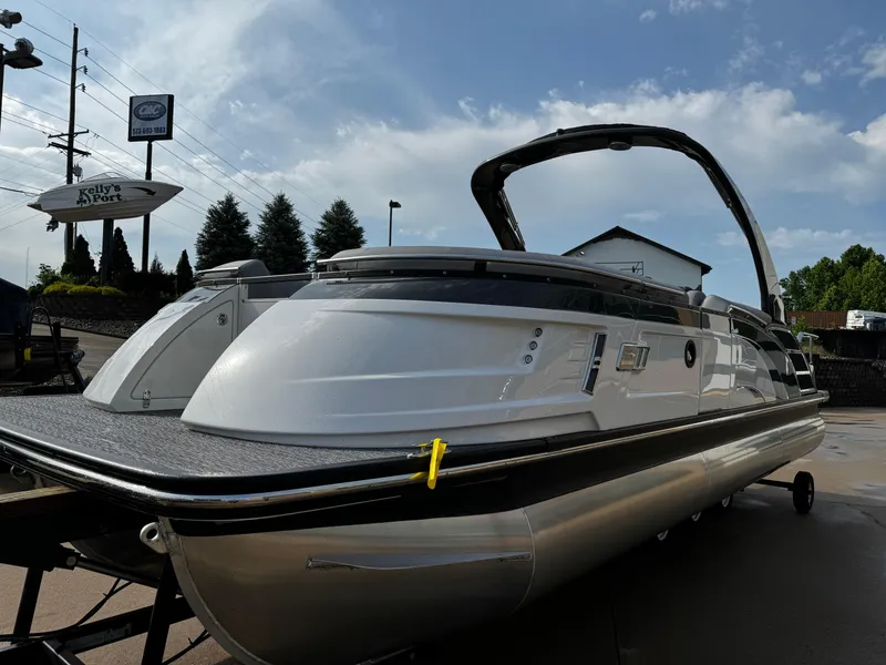 Slide: The Image of 2024 Bennington 25 QXSBA pontoon boat displayed outdoors under a clear sky. - 5