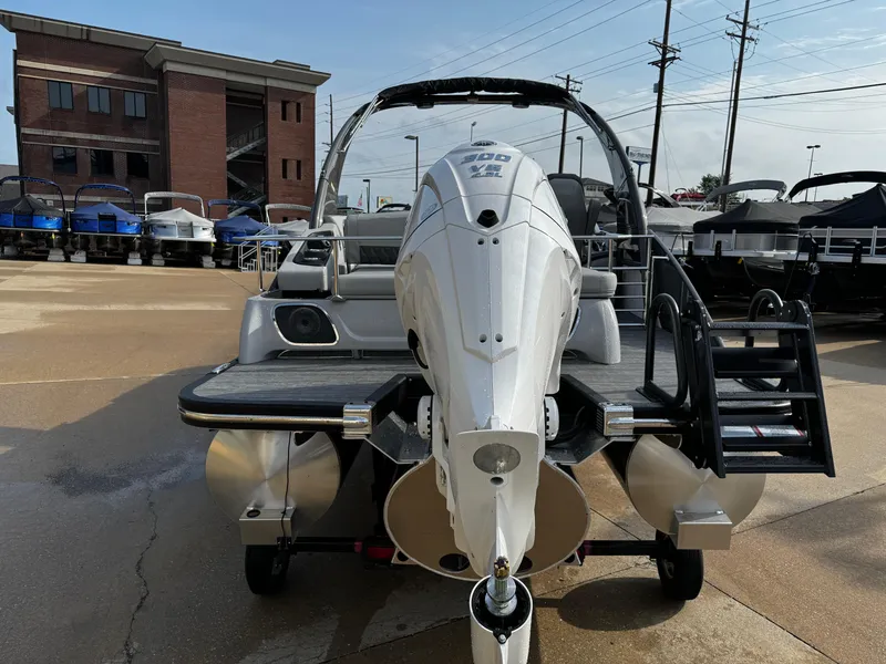 Slide: The Image of 2024 Bennington 25 QXSBA pontoon boat with powerful outboard motor, displayed outdoors. - 8