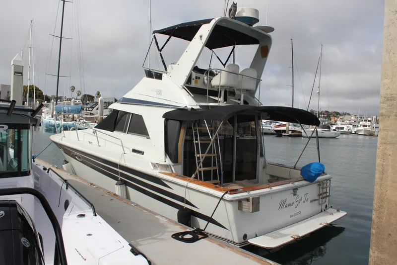 Slide: The Image of 1985 Trojan 10m Fly yacht docked at marina, featuring flybridge and spacious deck. - 1