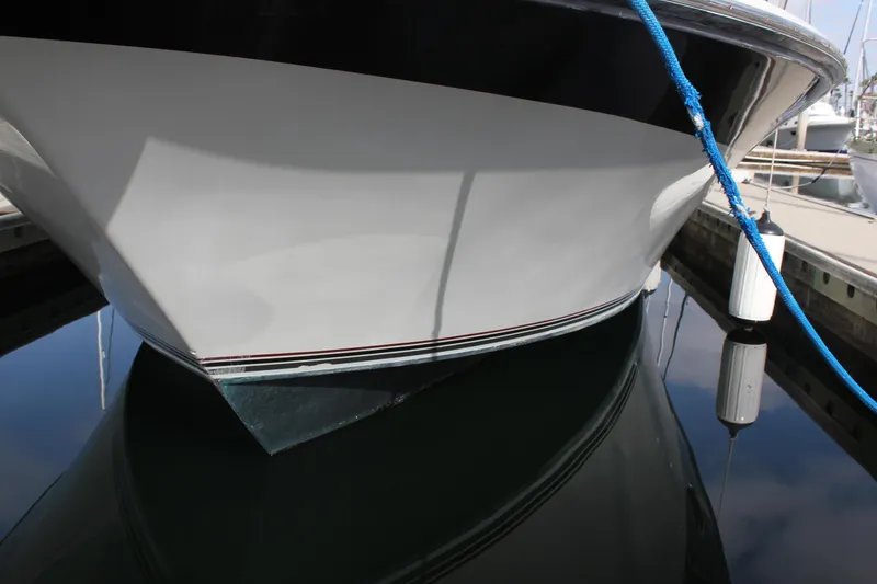 Slide: The Image of 1985 Trojan 10m Fly boat docked, reflecting on calm water. - 18