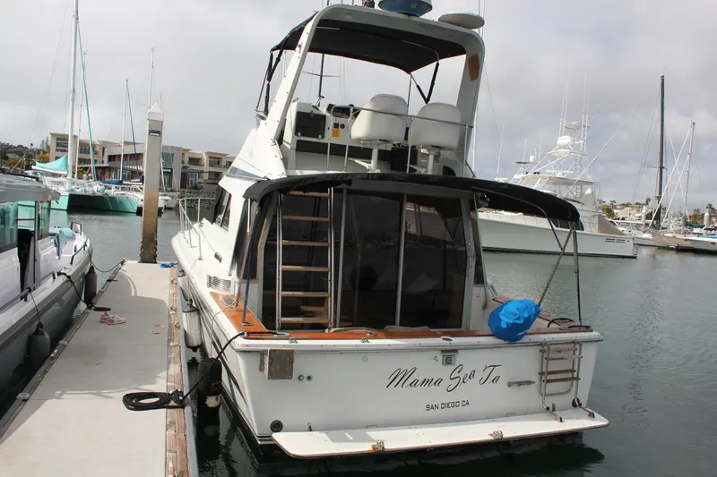 Slide: The Image of 1985 Trojan 10m Fly yacht docked in marina, rear view. - 2