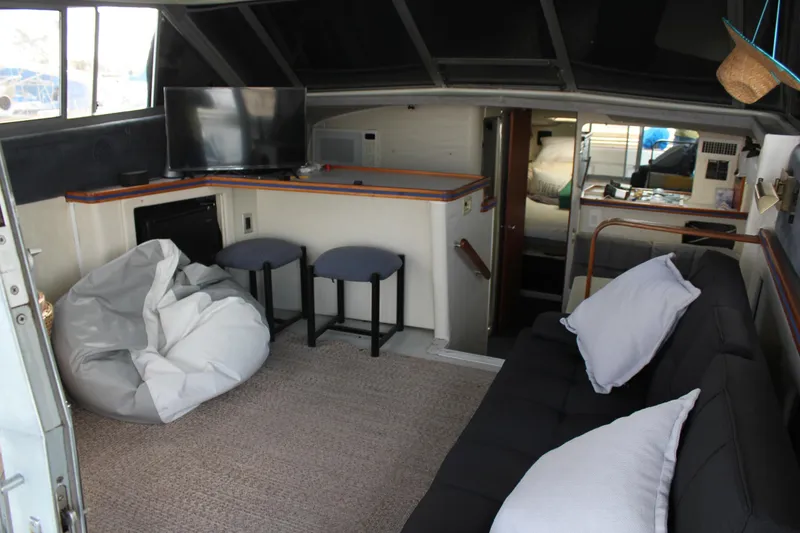 Slide: The Image of Interior of 1985 Trojan 10m Fly yacht with seating, TV, and cozy decor. - 21