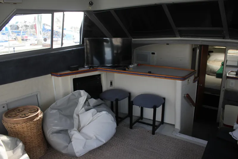 Slide: The Image of Interior of 1985 Trojan 10m Fly yacht with TV, seating, and bean bag. - 22