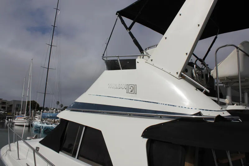 Slide: The Image of 1985 Trojan 10m Fly yacht docked at marina under cloudy sky. - 3