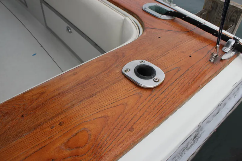 Slide: The Image of 1985 Trojan 10m Fly boat deck with polished wood finish and metal fittings. - 6