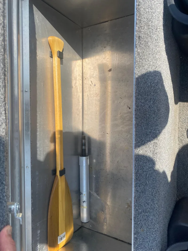 Slide: The Image of 2019 Bass Tracker Classic storage compartment with paddle and metal rod. - 17
