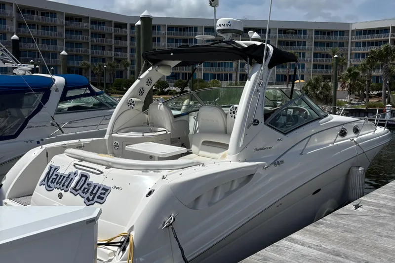 Slide: The Image of 2003 Sea Ray 340 Sundancer docked at marina, featuring sleek design and spacious deck. - 0