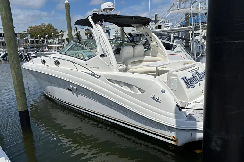 Slide: The Image of 2003 Sea Ray 340 Sundancer yacht docked in marina, featuring sleek white design. - 1