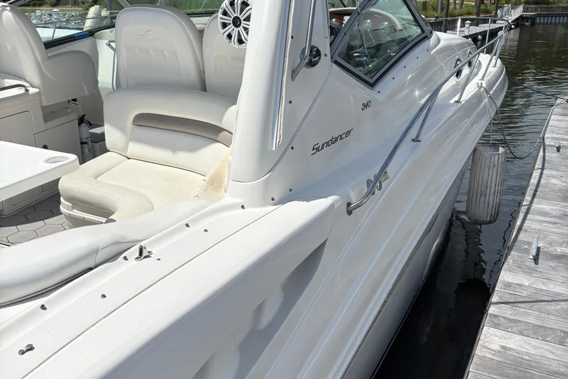 Slide: The Image of 2003 Sea Ray 340 Sundancer boat docked, featuring sleek white design and comfortable seating. - 10
