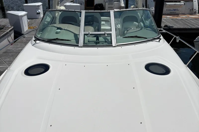 Slide: The Image of 2003 Sea Ray 340 Sundancer boat docked, showcasing sleek design and spacious deck. - 11