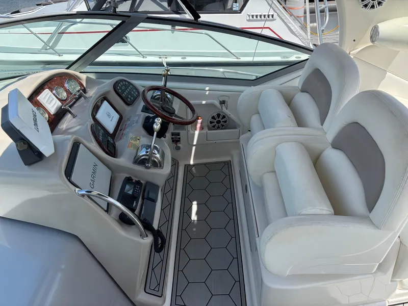 Slide: The Image of 2003 Sea Ray 340 Sundancer cockpit with dual white seats and modern controls. - 4