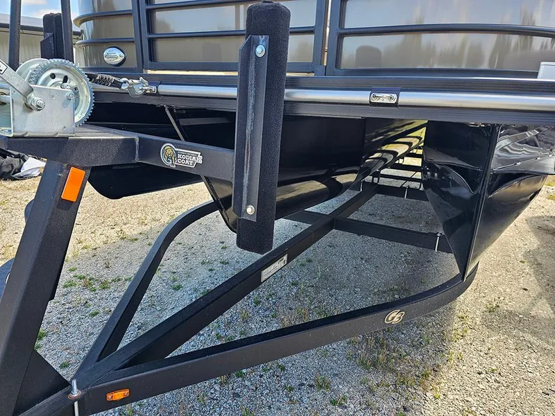 Slide: The Image of 2024 SunCatcher Elite 326 SE trailer hitch and frame detail on gravel surface. - 10