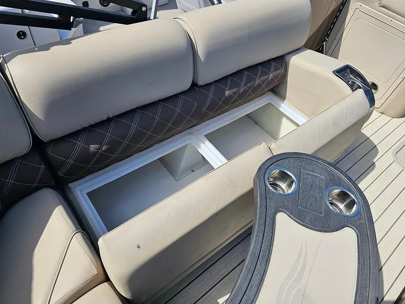 Slide: The Image of 2024 SunCatcher Elite 326 SE boat interior with storage compartments and cup holders. - 19