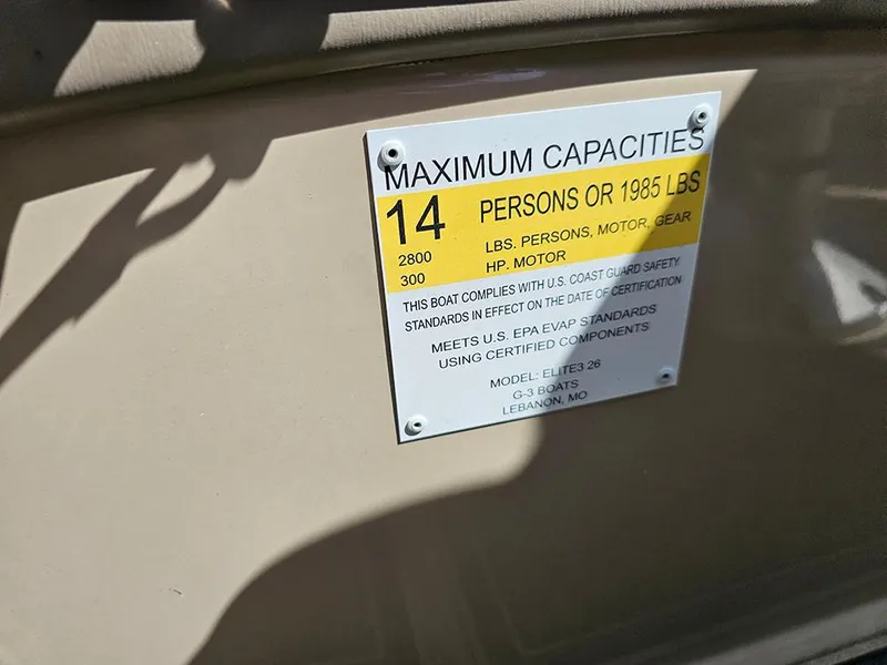 Slide: The Image of 2024 SunCatcher Elite 326 SE capacity plate, 14 persons or 1985 lbs, 300 HP motor. - 24