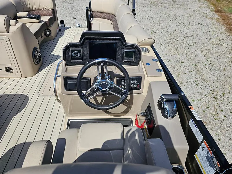 Slide: The Image of 2024 SunCatcher Elite 326 SE boat interior with steering wheel and beige seating. - 25
