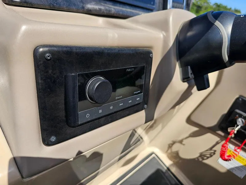 Slide: The Image of 2024 SunCatcher Elite 326 SE dashboard with audio control panel and ignition key. - 26