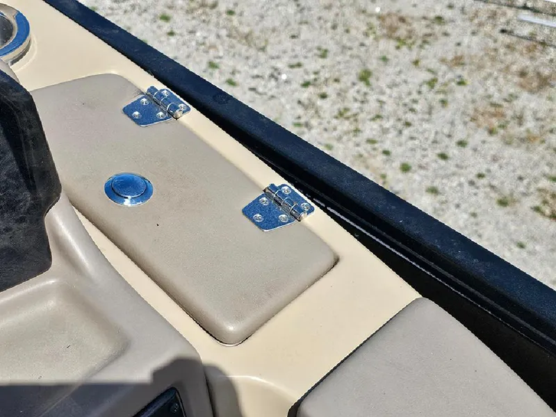 Slide: The Image of 2024 SunCatcher Elite 326 SE boat dashboard with beige panels and metal hinges. - 27