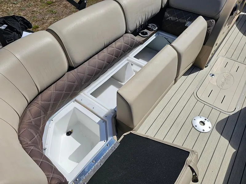 Slide: The Image of 2024 SunCatcher Elite 326 SE boat interior with open storage compartments and beige seating. - 32