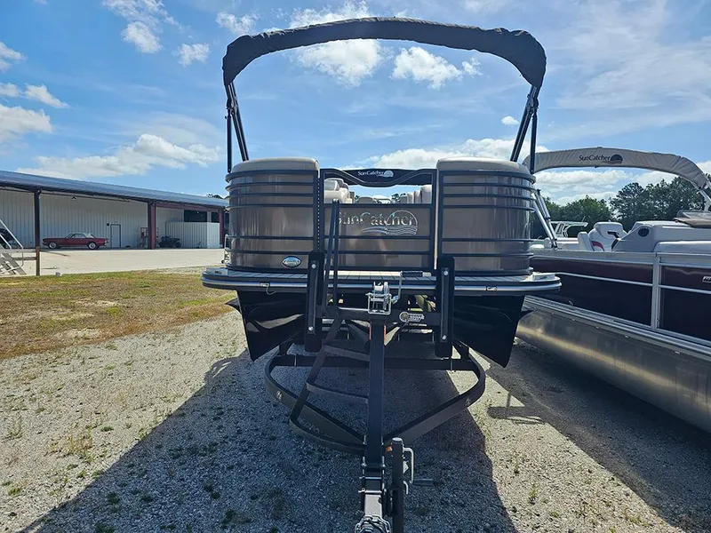 Slide: The Image of 2024 SunCatcher Elite 326 SE pontoon boat on trailer, parked outdoors under blue sky. - 4