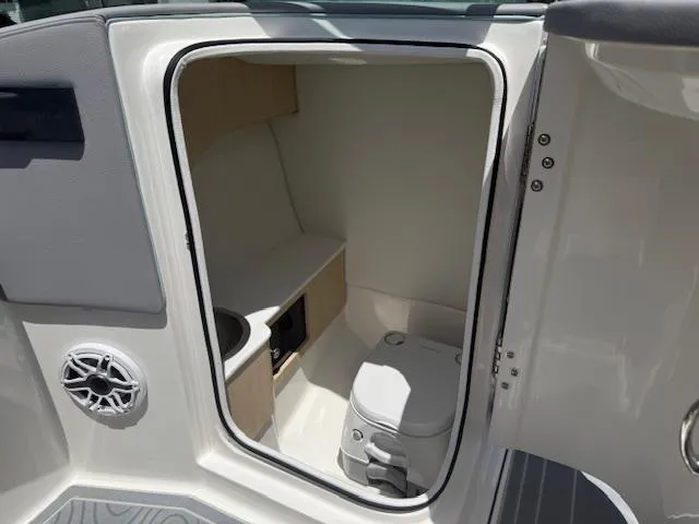 Slide: The Image of 2025 Regal LS6 Surf boat interior with compact bathroom and storage space. - 14