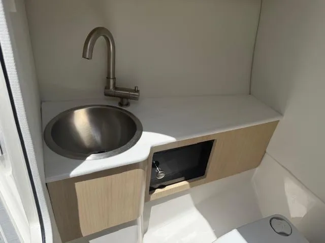 Slide: The Image of Compact sink area in 2025 Regal LS6 Surf boat, featuring modern faucet and storage. - 15