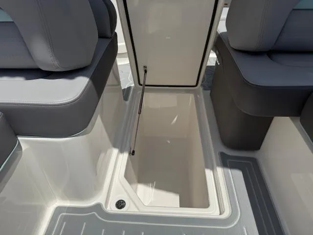 Slide: The Image of 2025 Regal LS6 Surf boat interior storage compartment with gray seating. - 16