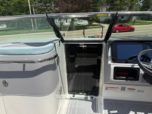 Slide: The Image of 2025 Regal LS6 Surf boat interior with open cabin door and steering console. - 18