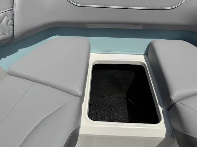 Slide: The Image of 2025 Regal LS6 Surf boat interior with open storage compartment and gray seating. - 24