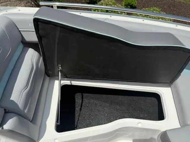 Slide: The Image of 2025 Regal LS6 Surf boat storage compartment with open cushioned seat. - 26