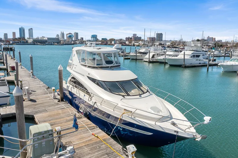 Slide: The Image of 2007 Marquis 55 LS yacht docked in a marina with city skyline in background. - 6