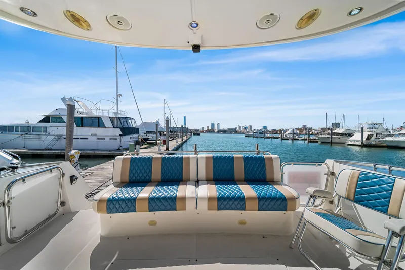 Slide: The Image of Luxury yacht Marquis 55 LS 2007 with stylish seating, docked at a marina with city skyline view. - 9