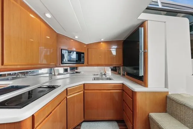 Slide: The Image of 1998 Viking 43 Open yacht kitchen with wooden cabinets, modern appliances, and sleek countertops. - 30