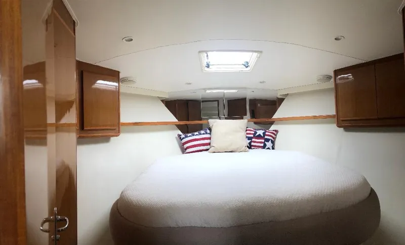 Slide: The Image of 1998 Viking 43 Open yacht cabin with cozy bed and wooden cabinets. - 49