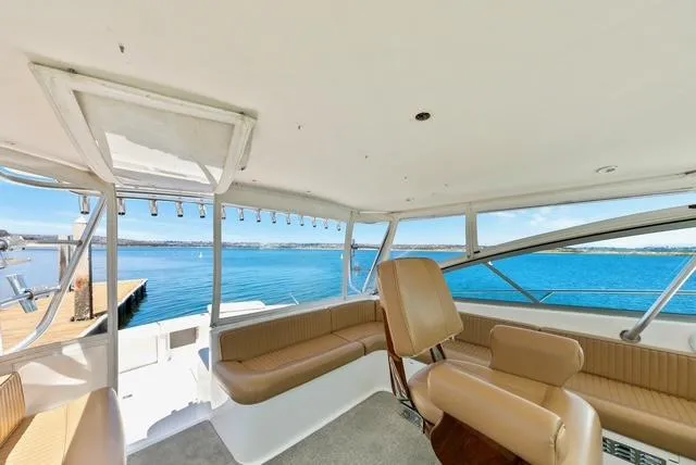Slide: The Image of 1998 Viking 43 Open yacht interior with beige seating, overlooking a serene blue sea. - 8