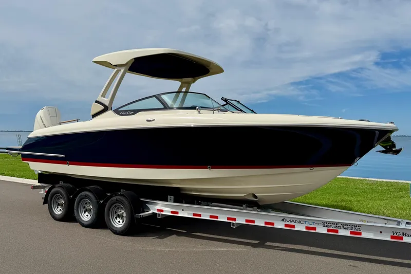 The Image of 2026 Chris-Craft Sportster 28 boat on trailer by waterfront, showcasing sleek design and modern features. - 0