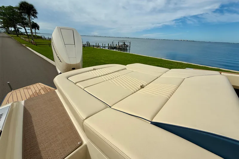 Slide: The Image of 2026 Chris-Craft Sportster 28 boat with luxurious seating by a serene waterfront. - 10