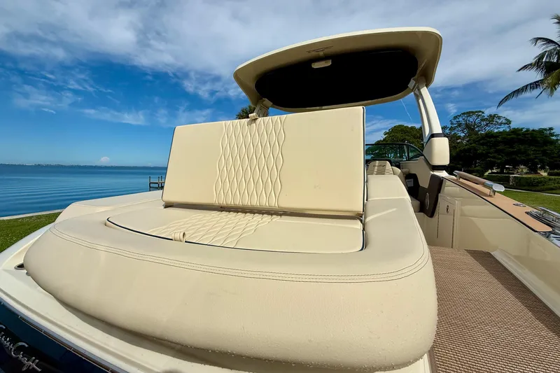 Slide: The Image of 2026 Chris-Craft Sportster 28 boat with luxurious seating, docked by a serene lake. - 11