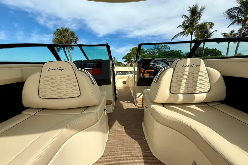 Slide: The Image of 2026 Chris-Craft Sportster 28 interior with luxurious seating and modern dashboard, under clear skies. - 18