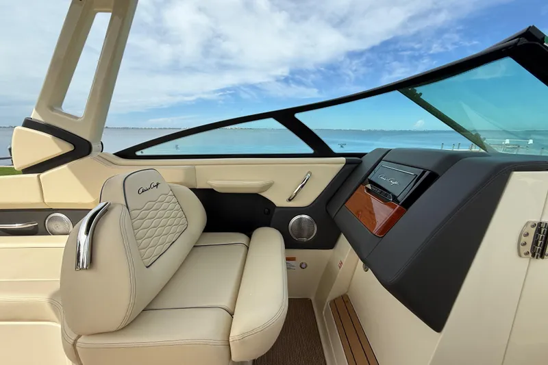 Slide: The Image of 2026 Chris-Craft Sportster 28 interior with luxurious seating and dashboard, overlooking serene waters. - 22