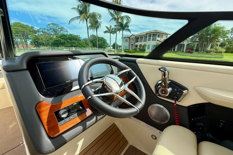 Slide: The Image of 2026 Chris-Craft Sportster 28 dashboard with luxury steering and control panel, scenic view outside. - 26