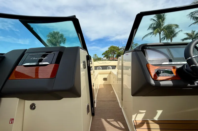 Slide: The Image of 2026 Chris-Craft Sportster 28 boat interior with dashboard, palm trees in background. - 29