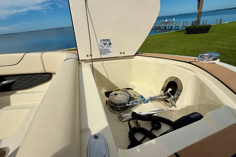 Slide: The Image of 2026 Chris-Craft Sportster 28 boat interior with open storage compartment by the water. - 31