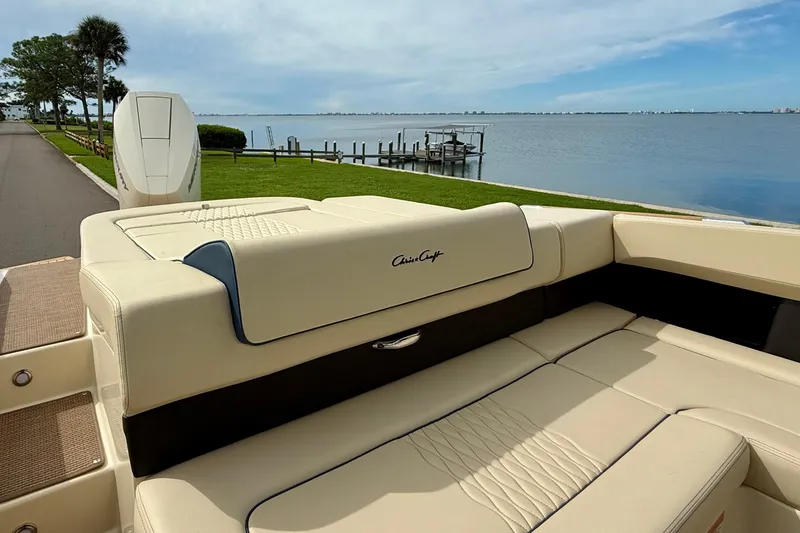 Slide: The Image of 2026 Chris-Craft Sportster 28 boat with luxurious seating by a serene waterfront. - 8