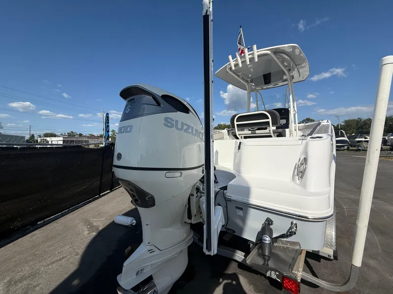 Slide: The Image of 2022 Aquasport 2300 Center Console boat with Suzuki outboard motor, parked outdoors. - 26