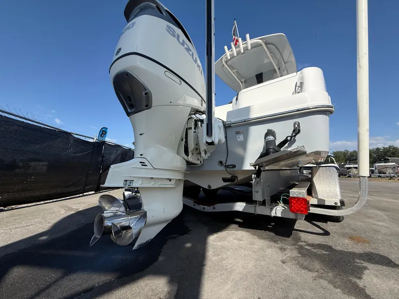 Slide: The Image of 2022 Aquasport 2300 Center Console boat with powerful outboard motor, docked under clear skies. - 27