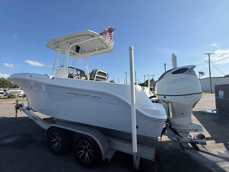 Slide: The Image of 2022 Aquasport 2300 Center Console boat on trailer, featuring a powerful outboard motor. - 31