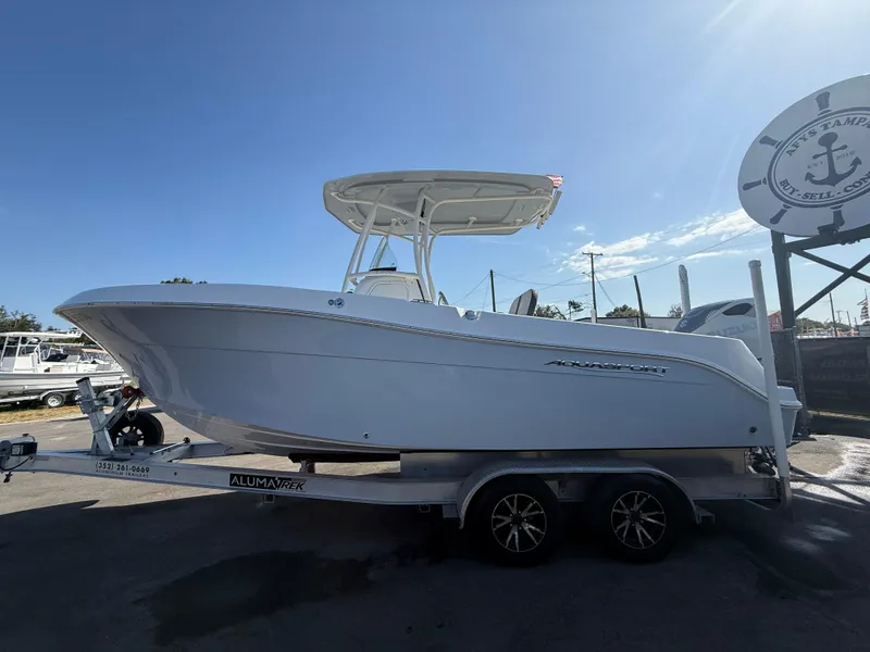 Slide: The Image of 2022 Aquasport 2300 Center Console boat on trailer under clear blue sky. - 32